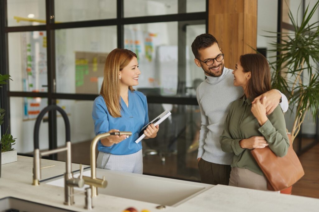 Real estate agent showing a modern home to a happy couple during a residential property tour.