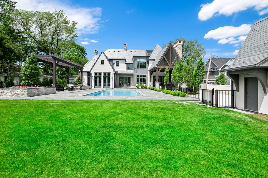 Luxury Custom Home with Resort Style Backyard and Pool Luxury custom home with spacious backyard, manicured green lawn, outdoor living area, and resort style swimming pool.