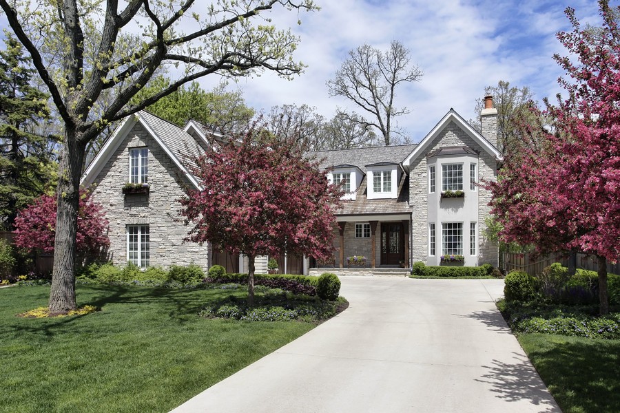 Traditional Family Home with Blooming Trees and Beautiful Landscaping Charming traditional family home with flowering trees, landscaped front yard, long driveway, and beautiful spring curb appeal in a quiet residential neighborhood.