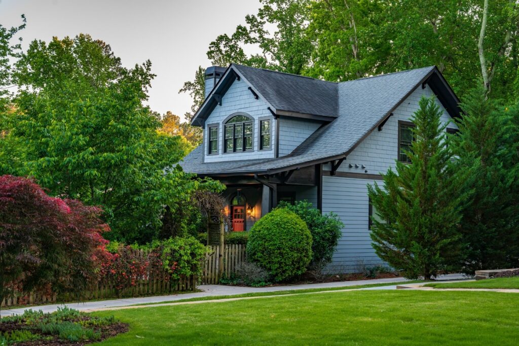 Charming Cottage Style Home with Beautiful Landscaping and Curb Appeal Charming cottage style home with steep gable roof, mature landscaping, flowering shrubs, and lush green lawn in a peaceful suburban neighborhood.